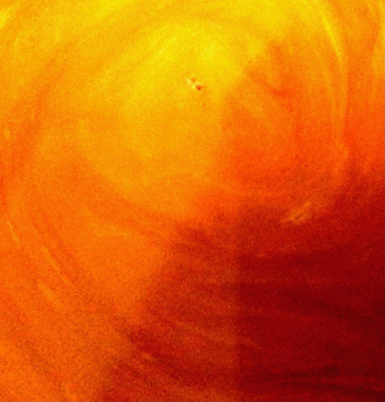 A close up of a painting of a swirl of orange and red paint.