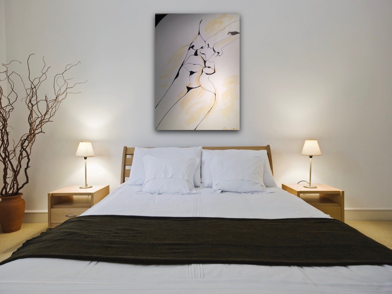 A bedroom with a large painting on the wall above the bed