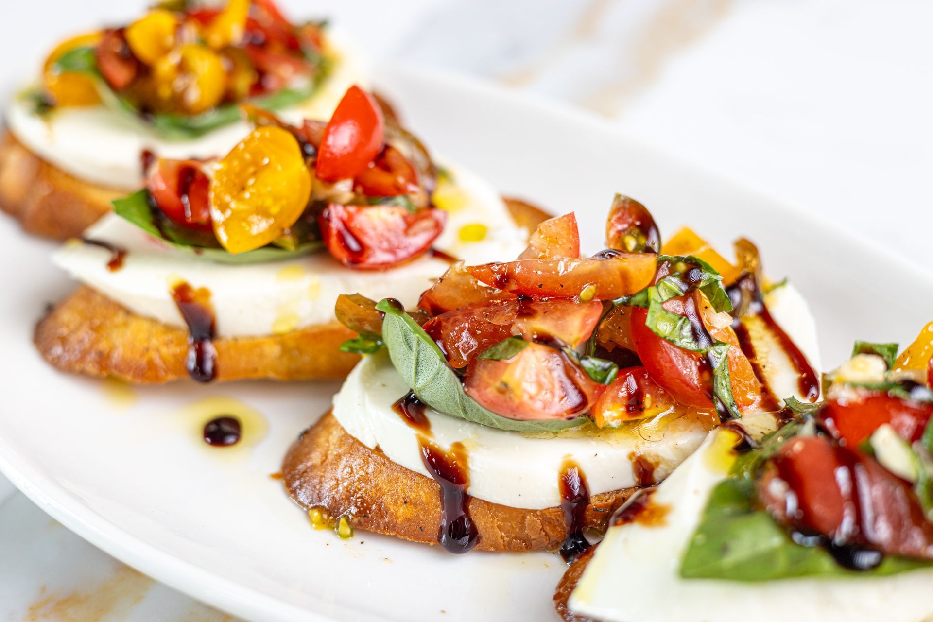 A close up of a plate of food with tomatoes and mozzarella on a table.