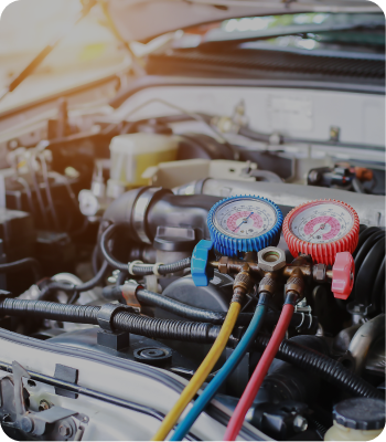Car engine with gauges and hoses attached for air conditioning service. | Destiny Vehicle Solutions