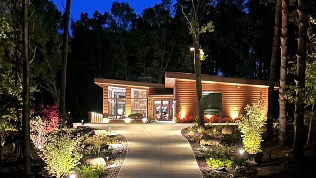 A house is lit up at night in the woods