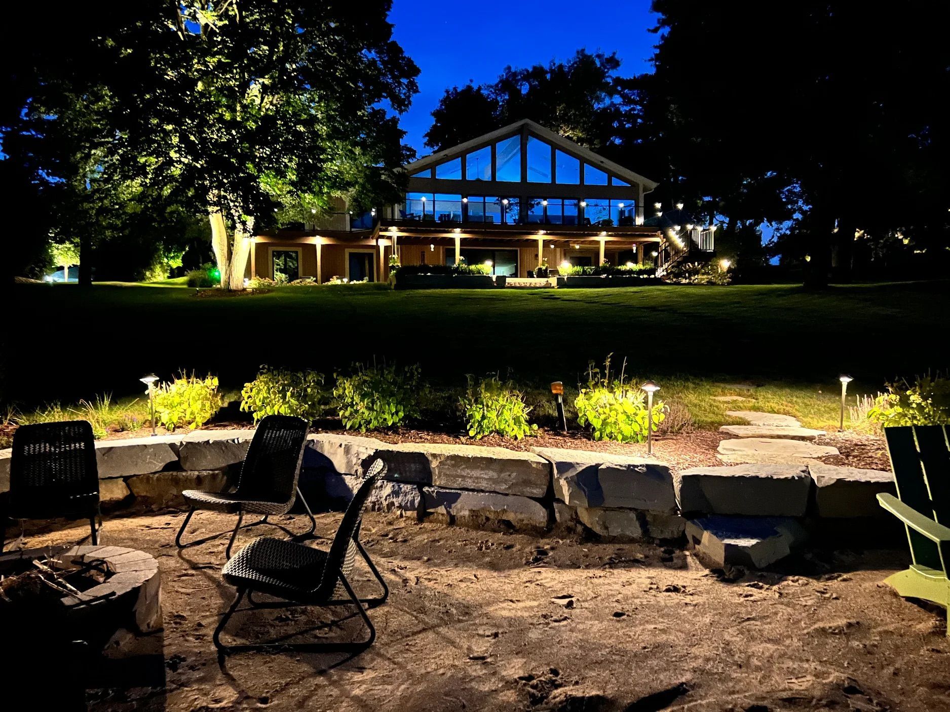The backyard of a house with a large deck and a walkway leading to it.