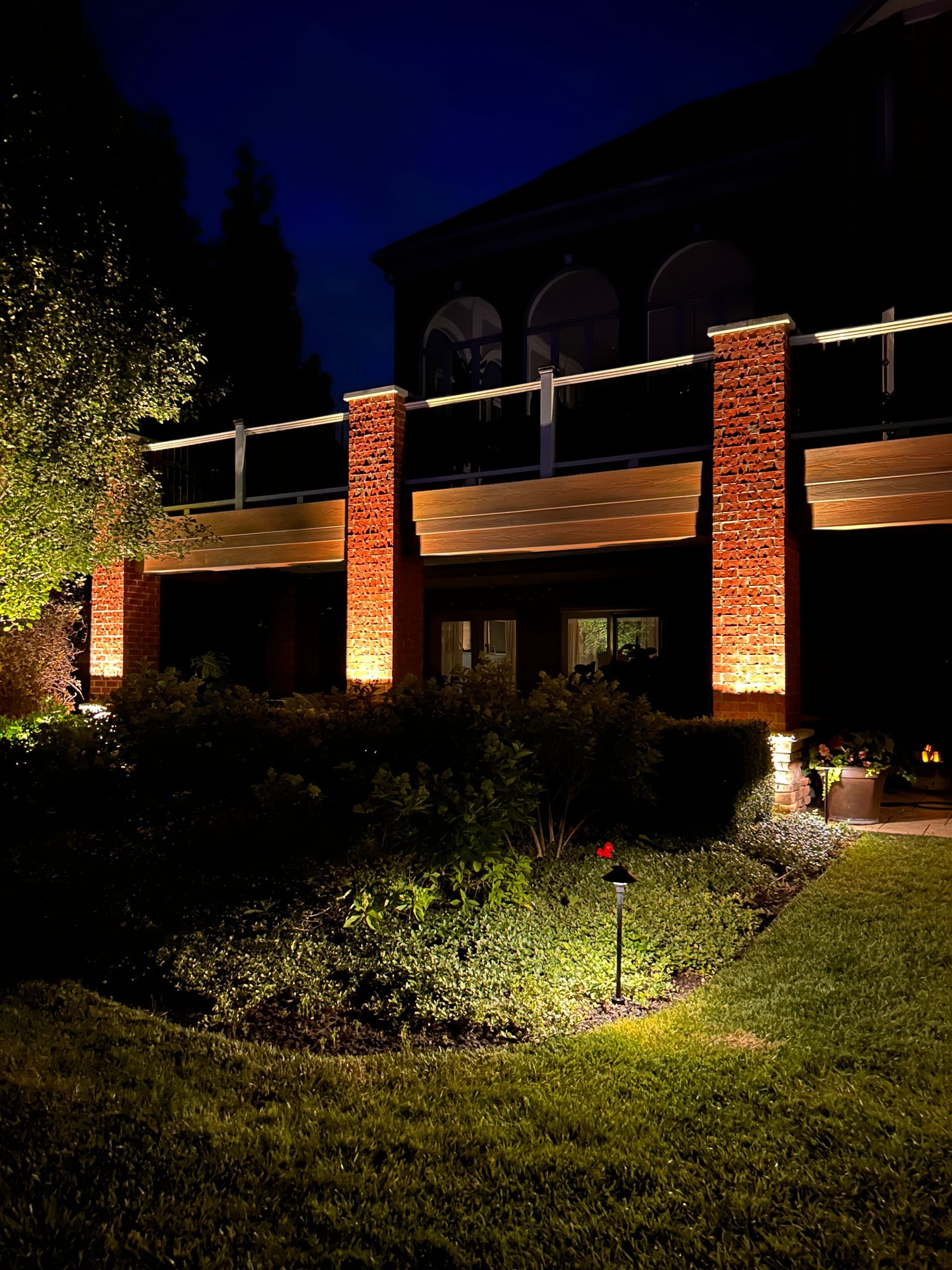 A house with a balcony is lit up at night