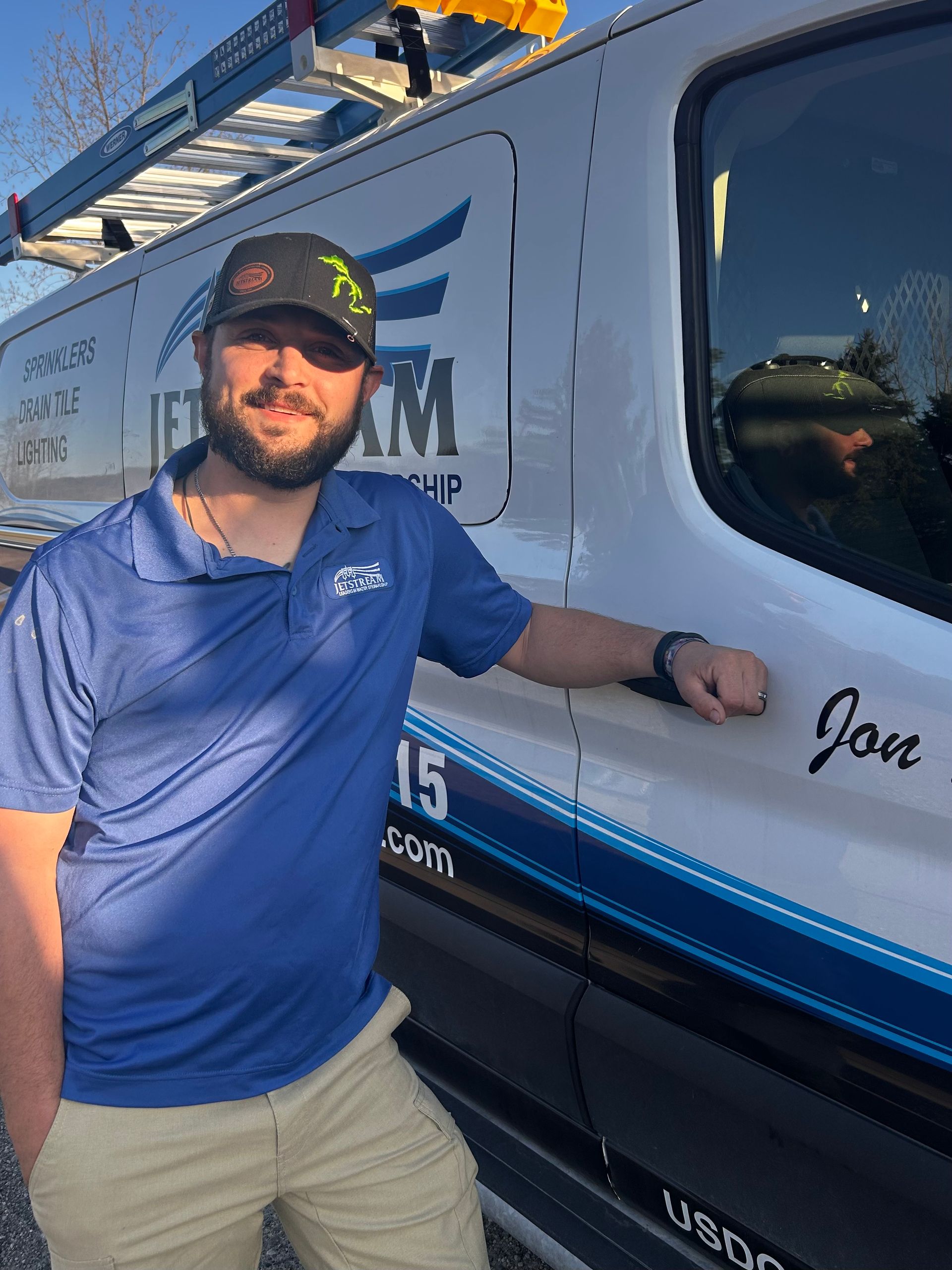 A man in a blue shirt is standing in front of a jetstream logo.