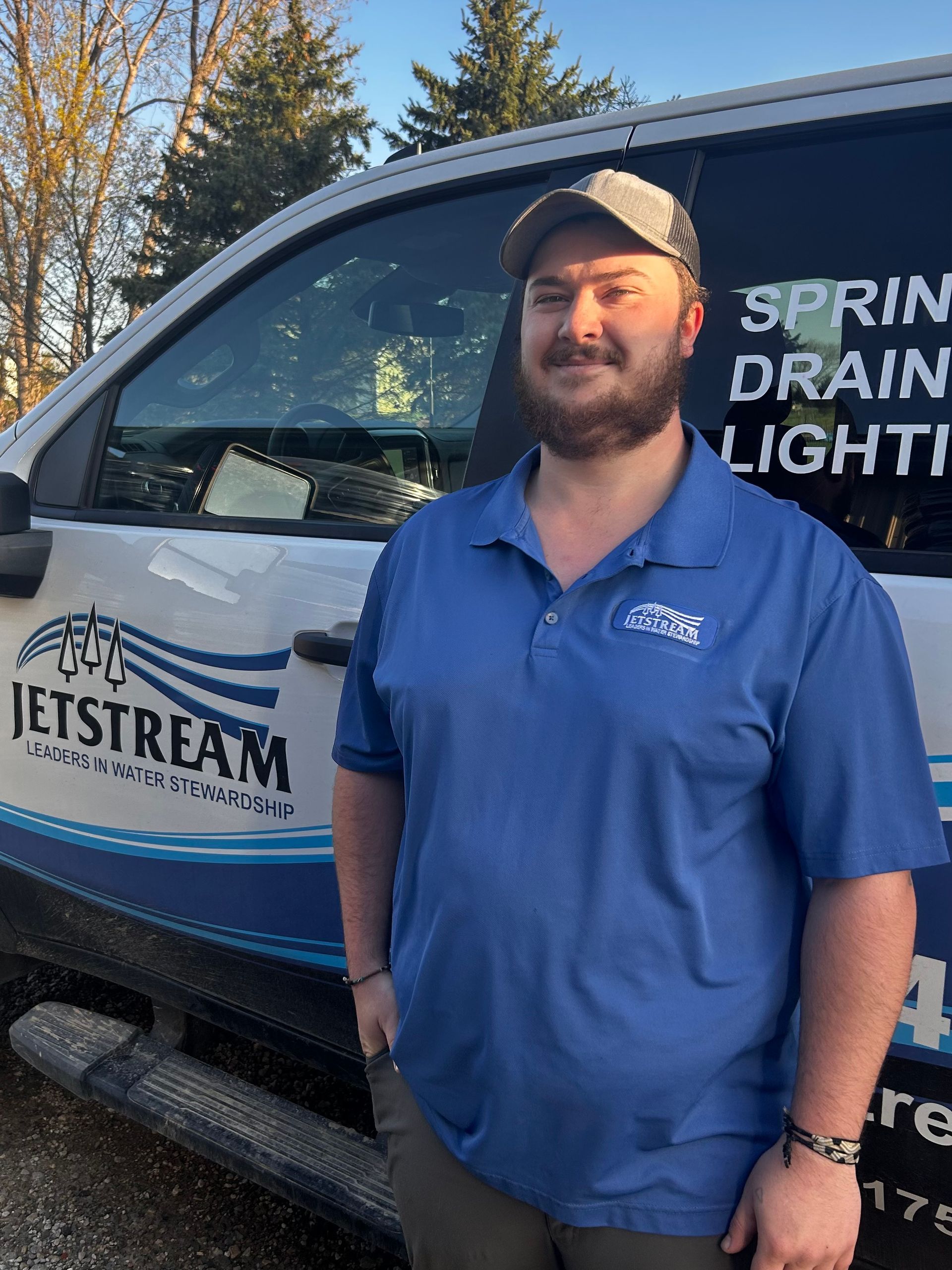 A man in a blue shirt is standing in front of a sign that says jetstream