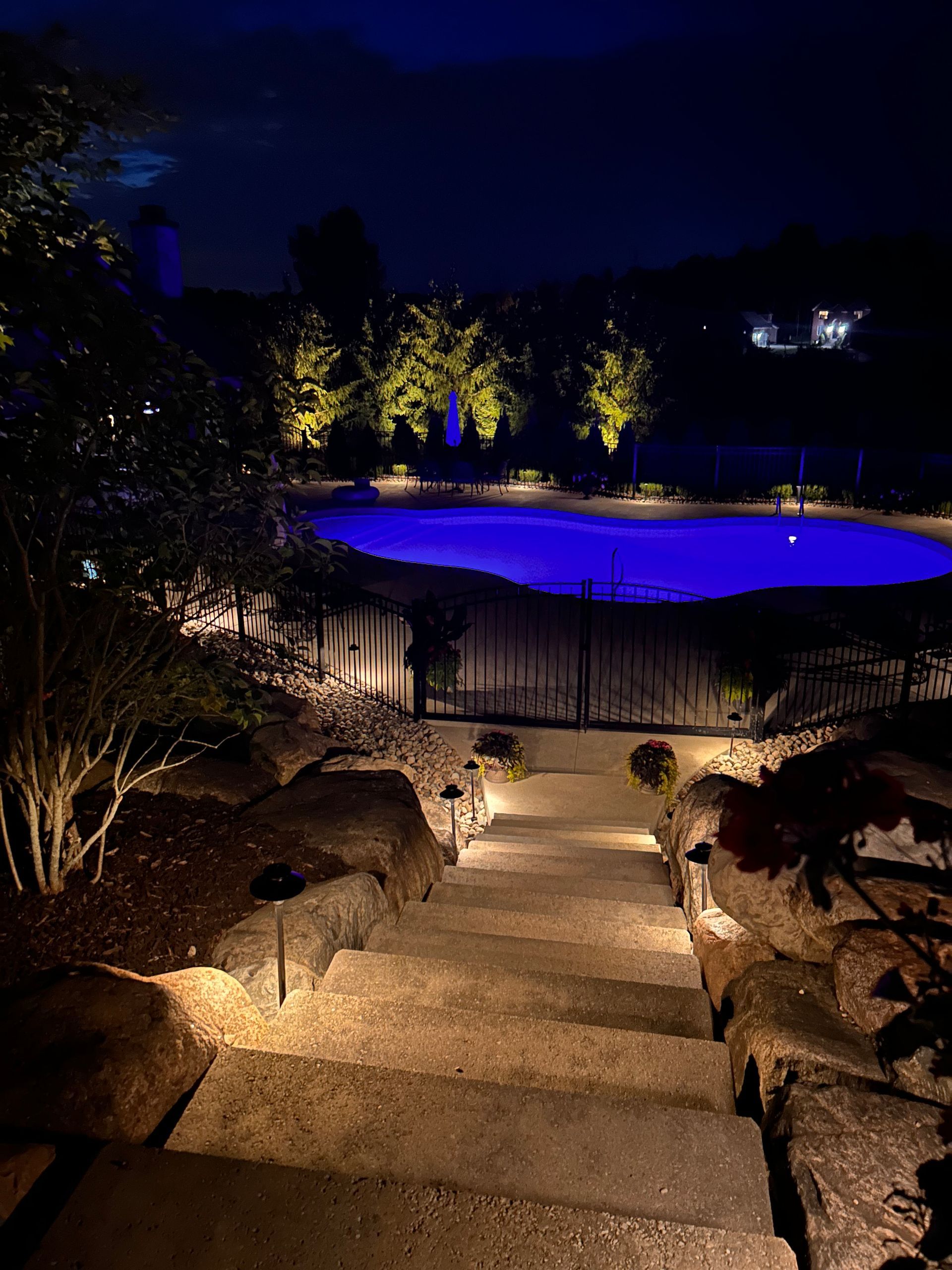 A staircase leading up to a swimming pool at night.