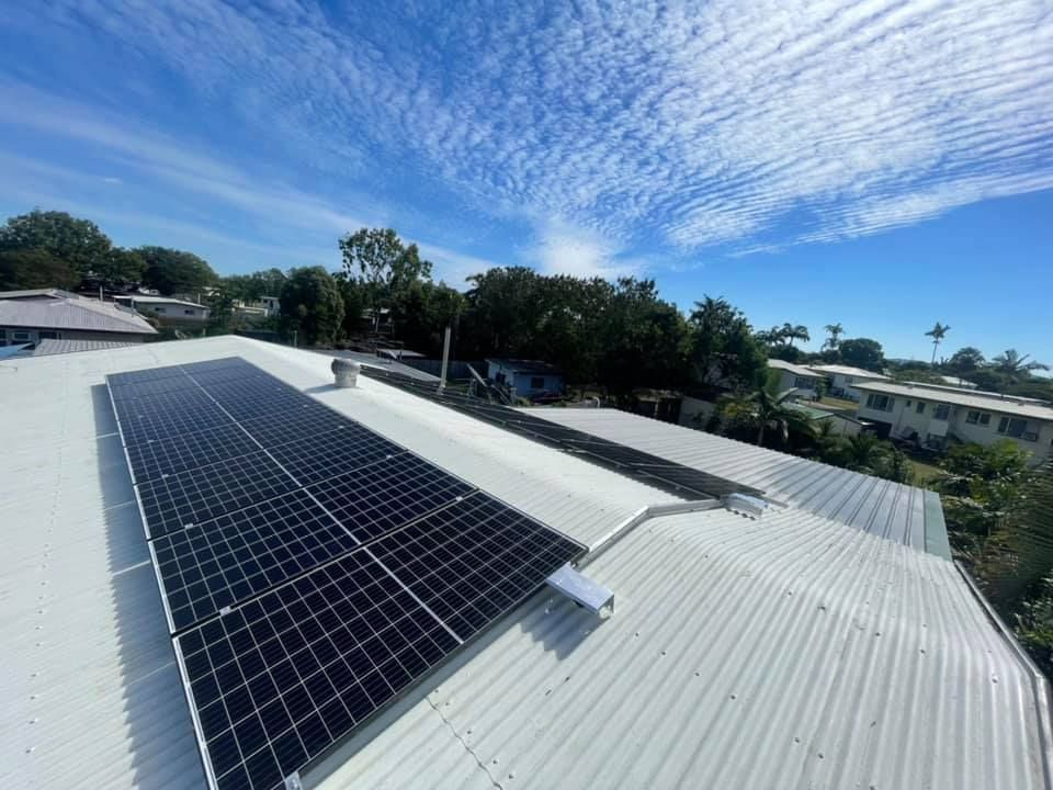 A Row Of Solar Panels Are Sitting On Top Of A White Roof — Waltlec Industries In Garbutt, QLD