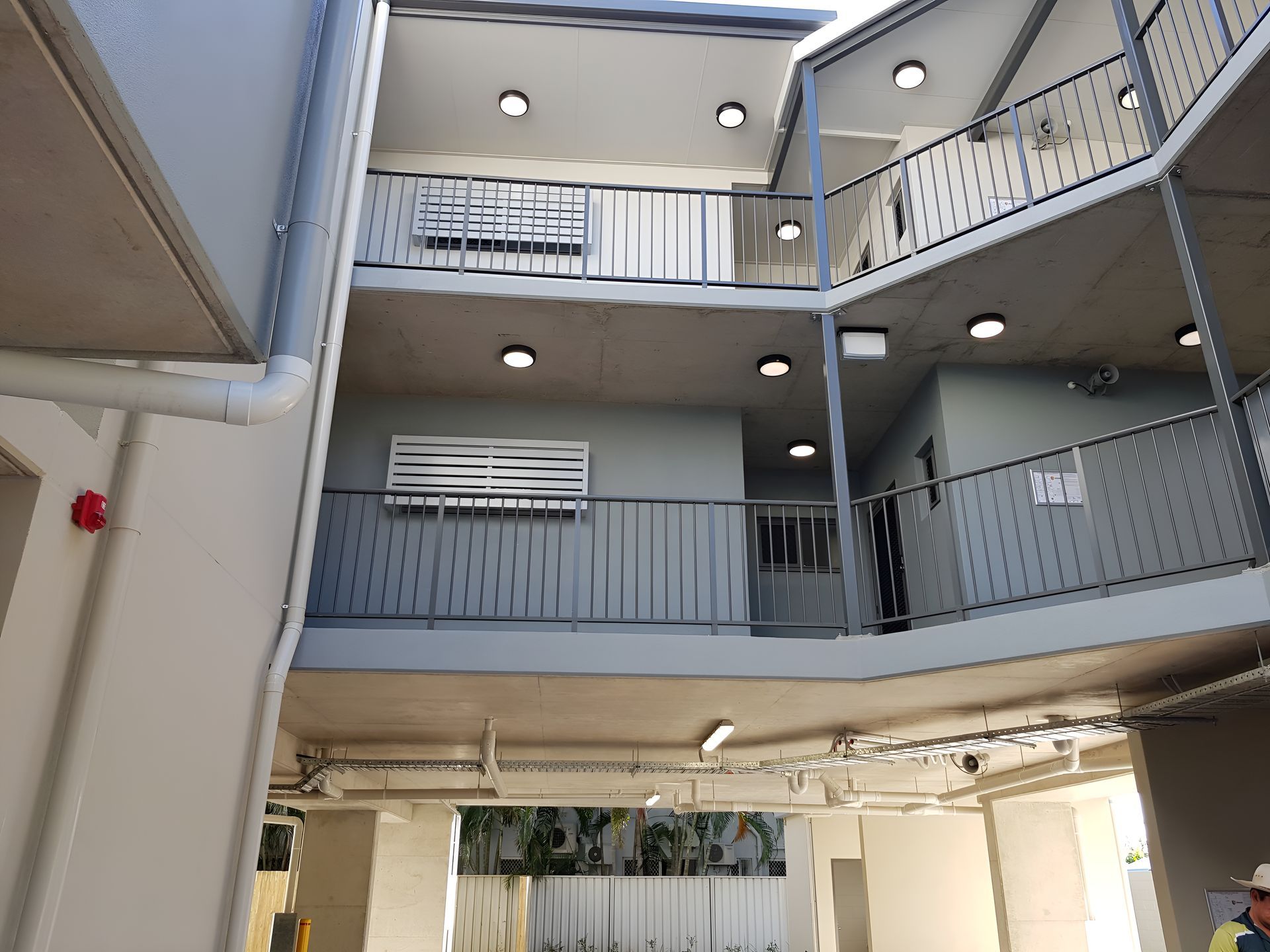 A man is standing in the middle of a building with balconies — Waltlec Industries In Garbutt, QLD