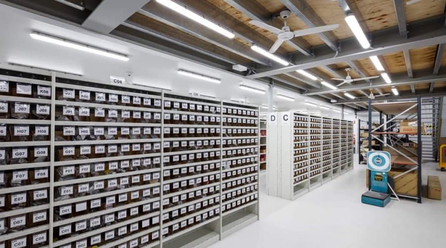 A Warehouse Filled with Lots of Shelves and A Ceiling Fan — Waltlec Industries In Garbutt, QLD