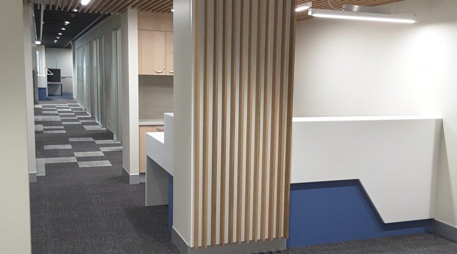 A Hallway in An Office Building with A Blue Counter and A Wooden Divider — Waltlec Industries In Garbutt, QLD