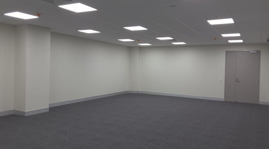 A Large Empty Room with White Walls and A Door — Waltlec Industries In Garbutt, QLD