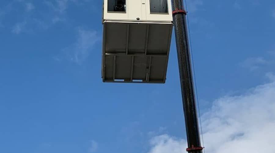 A Crane Is Lifting a Building Into the Air — Waltlec Industries In Garbutt, QLD