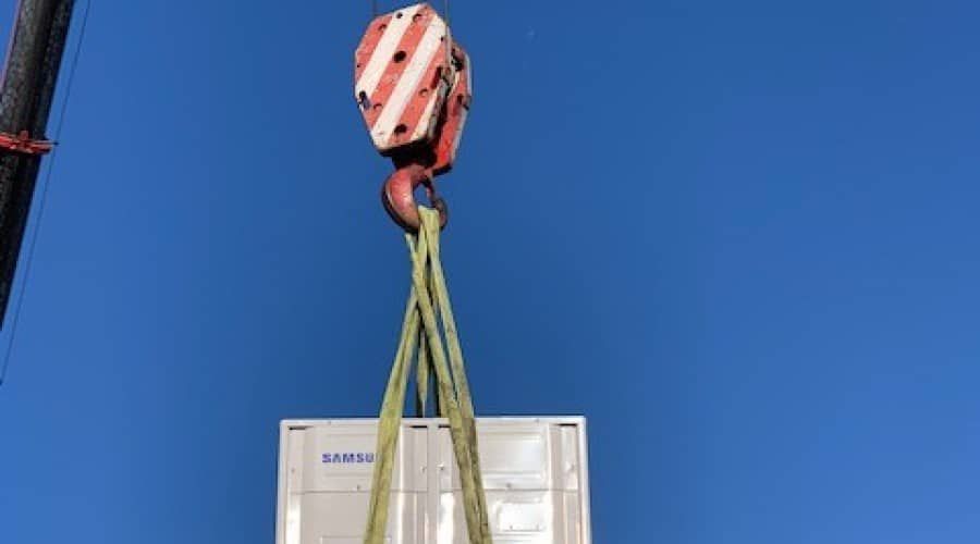 A Crane Is Lifting a Samsung Air Conditioner Into the Air — Waltlec Industries In Garbutt, QLD