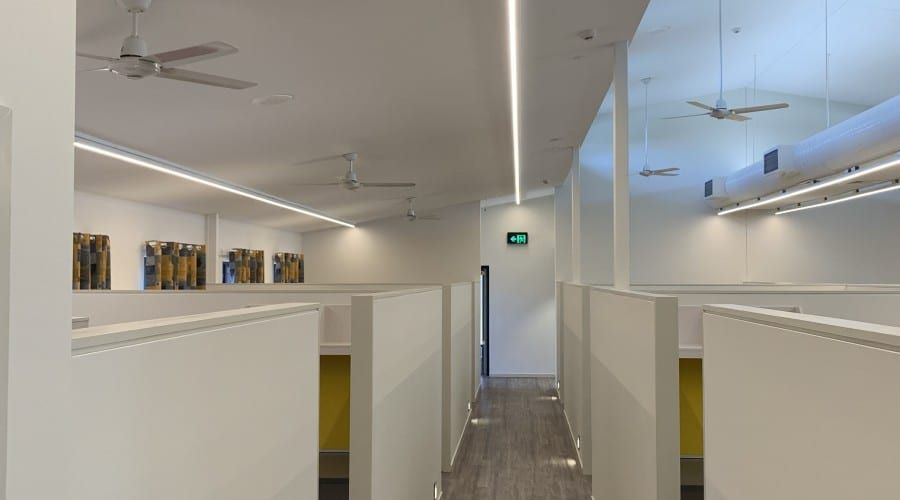 A Long Hallway in An Office Building with Cubicles and A Ceiling Fan — Waltlec Industries In Garbutt, QLD