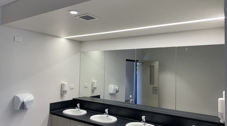 A Bathroom with Two Sinks and A Large Mirror — Waltlec Industries In Garbutt, QLD