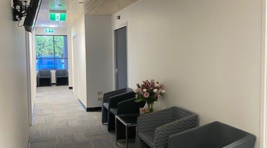 A Long Hallway with Chairs and A Vase of Flowers — Waltlec Industries In Garbutt, QLD
