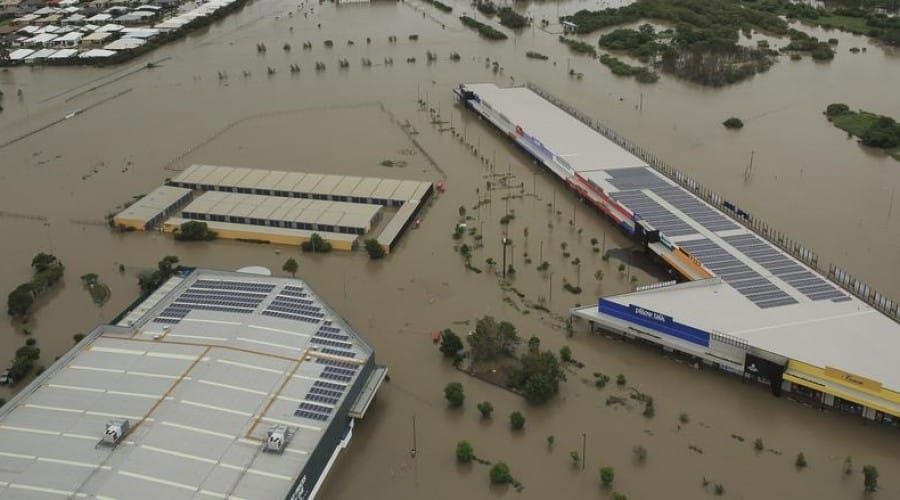 An Aerial View of A Flooded City with Buildings Covered in Water — Waltlec Industries In Garbutt, QLD