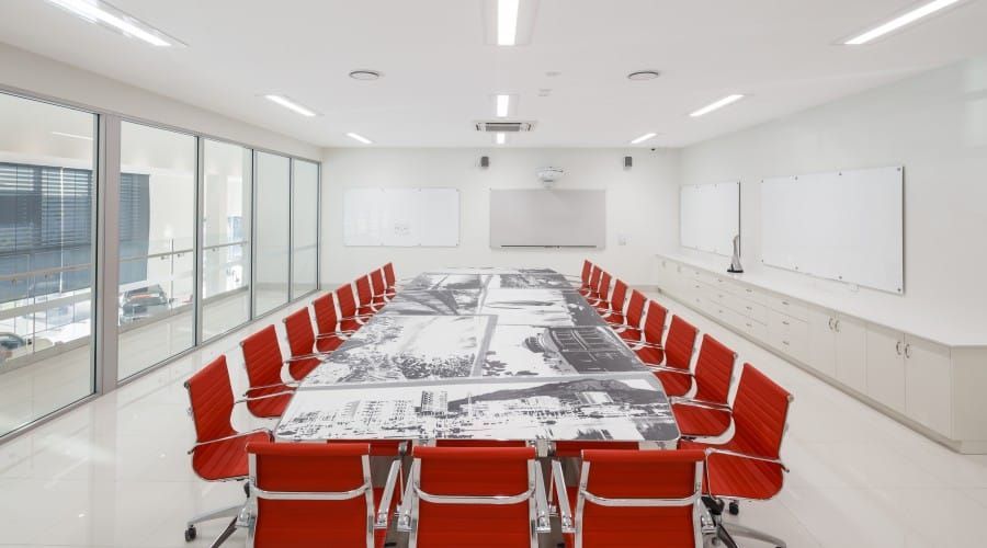 A Conference Room with A Long Table and Red Chairs — Waltlec Industries In Garbutt, QLD