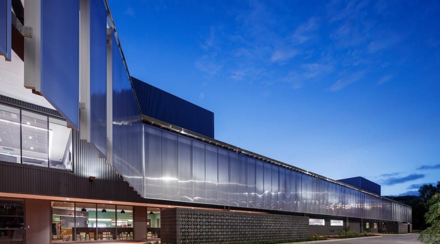 A Large Building with A Lot of Windows Is Lit up At Night — Waltlec Industries In Garbutt, QLD