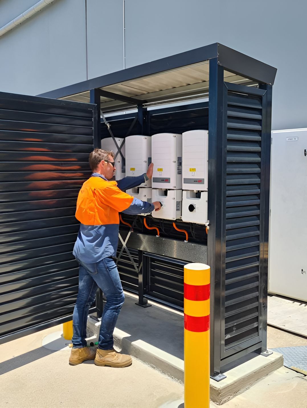 A Man In An Orange Shirt Is Working On A Solar Panel  — Waltlec Industries In Garbutt, QLD