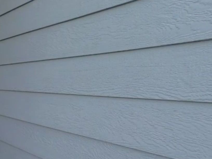 A close up of a light blue LP siding on a house.