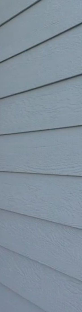 A close up of a light blue LP siding on a house.