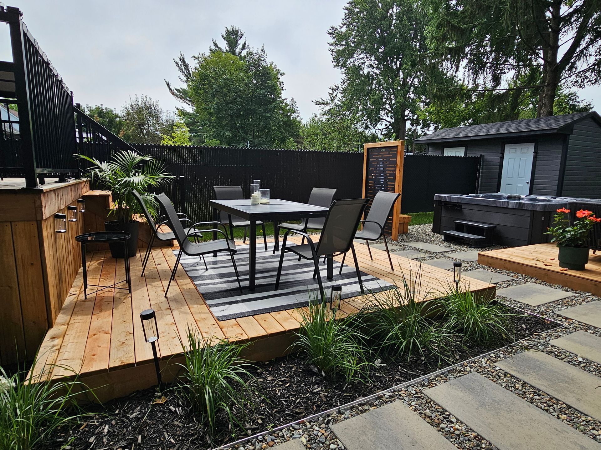 Il y a une table et des chaises sur la terrasse dans l'arrière-cour.