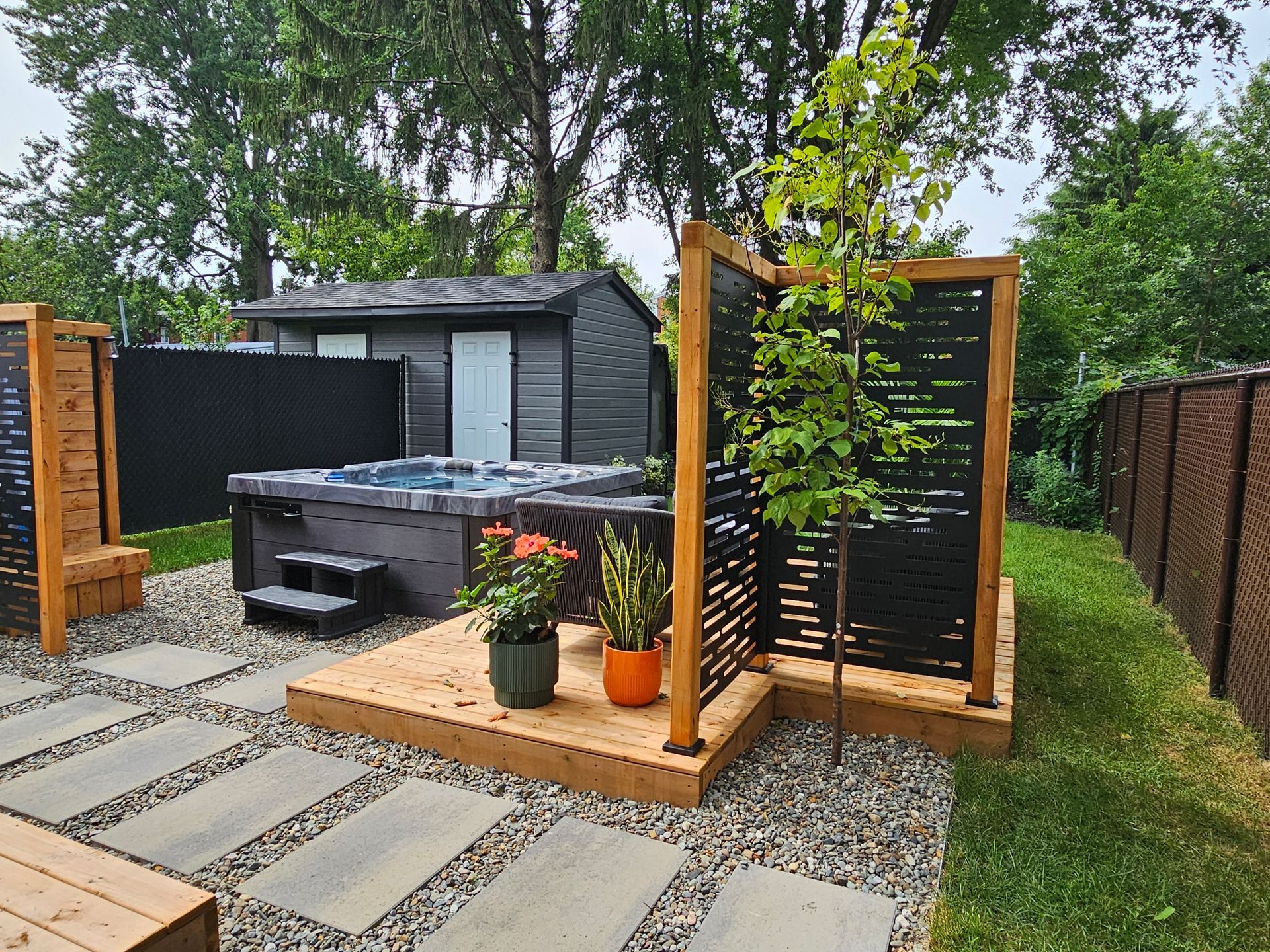 Un bain à remous est posé sur une plate-forme en bois dans une cour arrière.