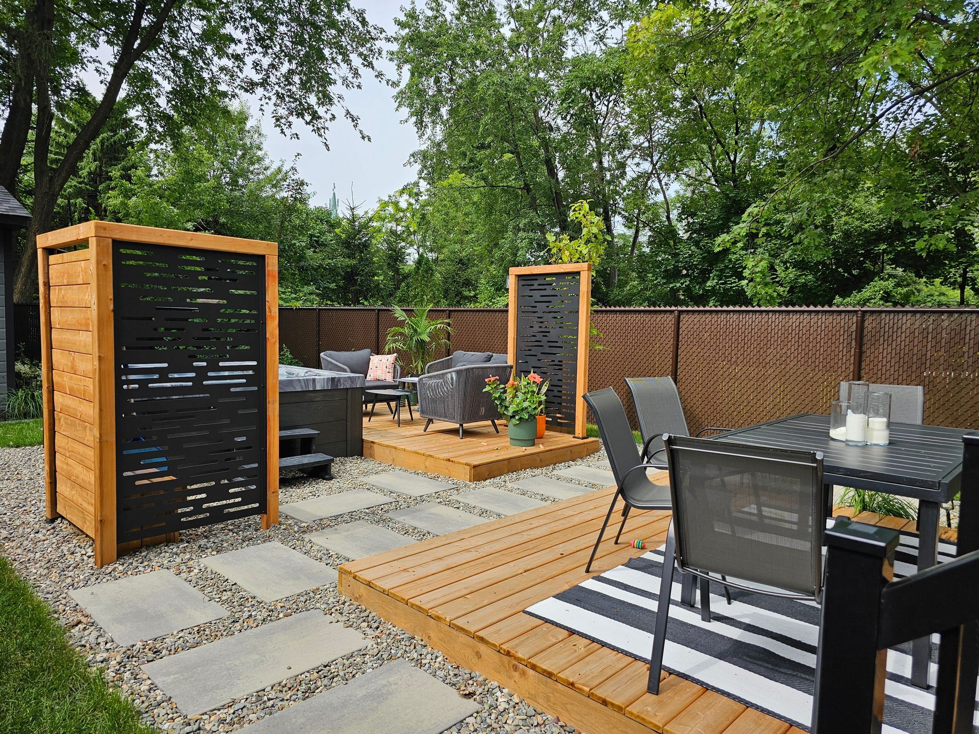 Un patio avec une table et des chaises et un tapis rayé.