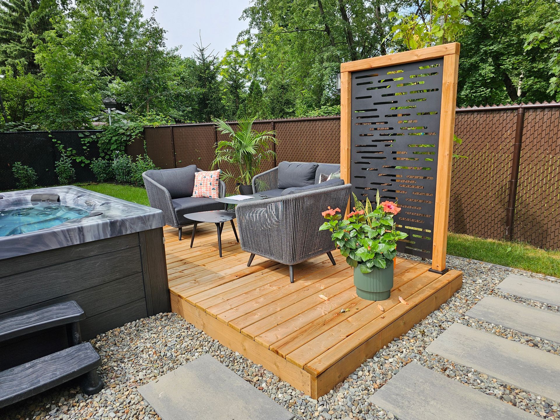 Une cour arrière avec un bain à remous, des meubles de patio et une terrasse en bois.