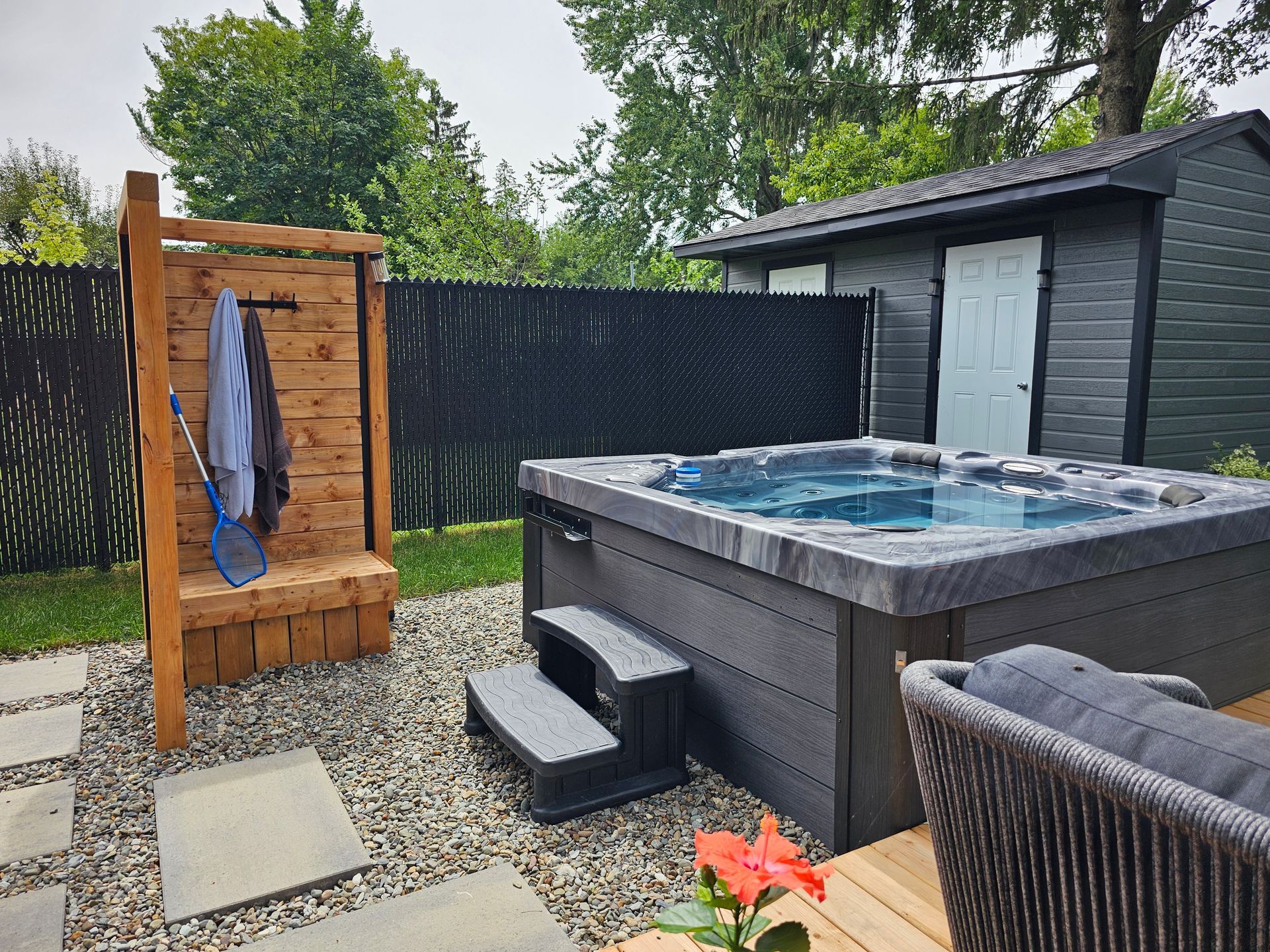 Un bain à remous est installé dans l'arrière-cour à côté d'un hangar.