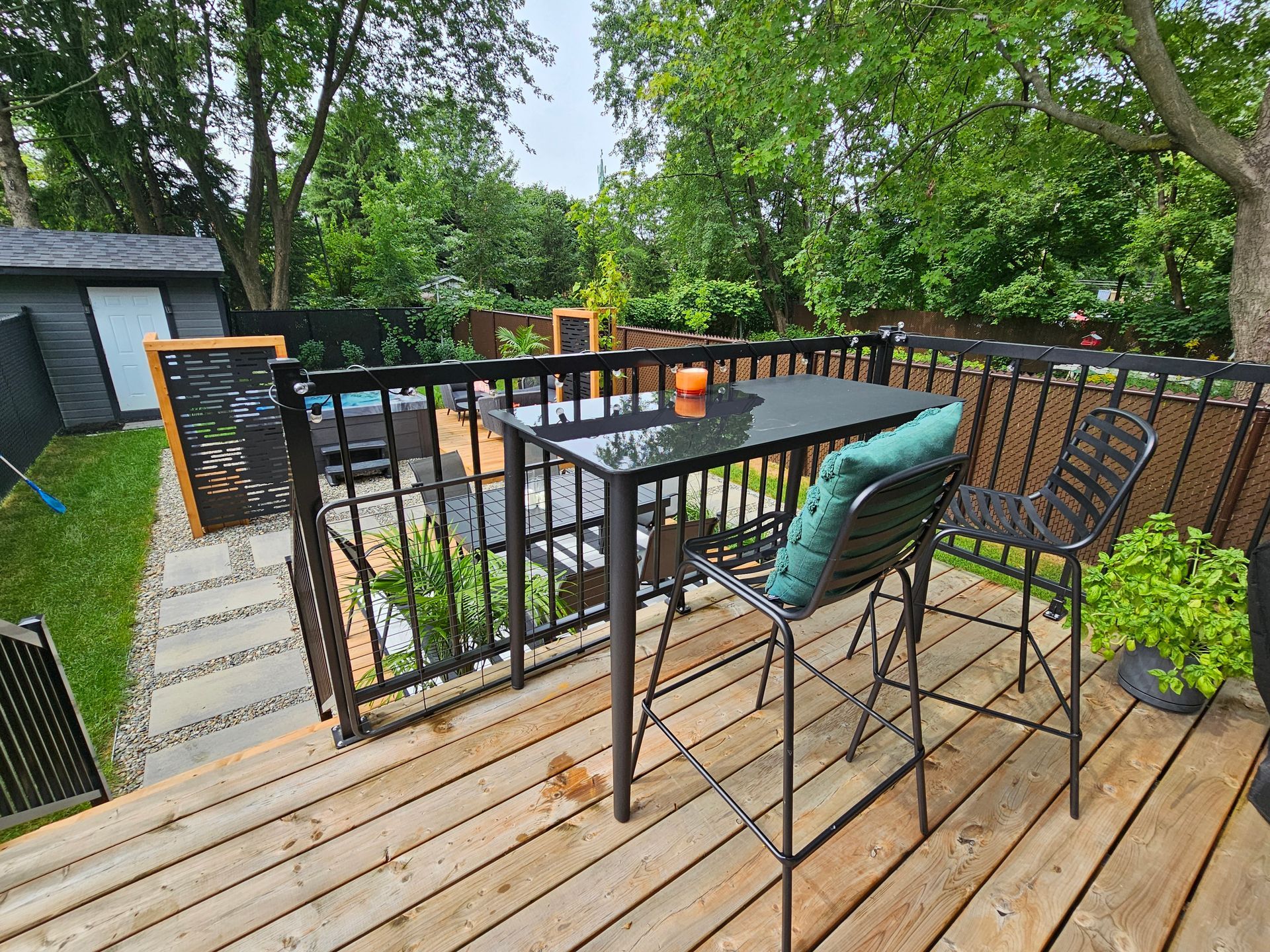 Une terrasse en bois avec une table et des chaises dessus.