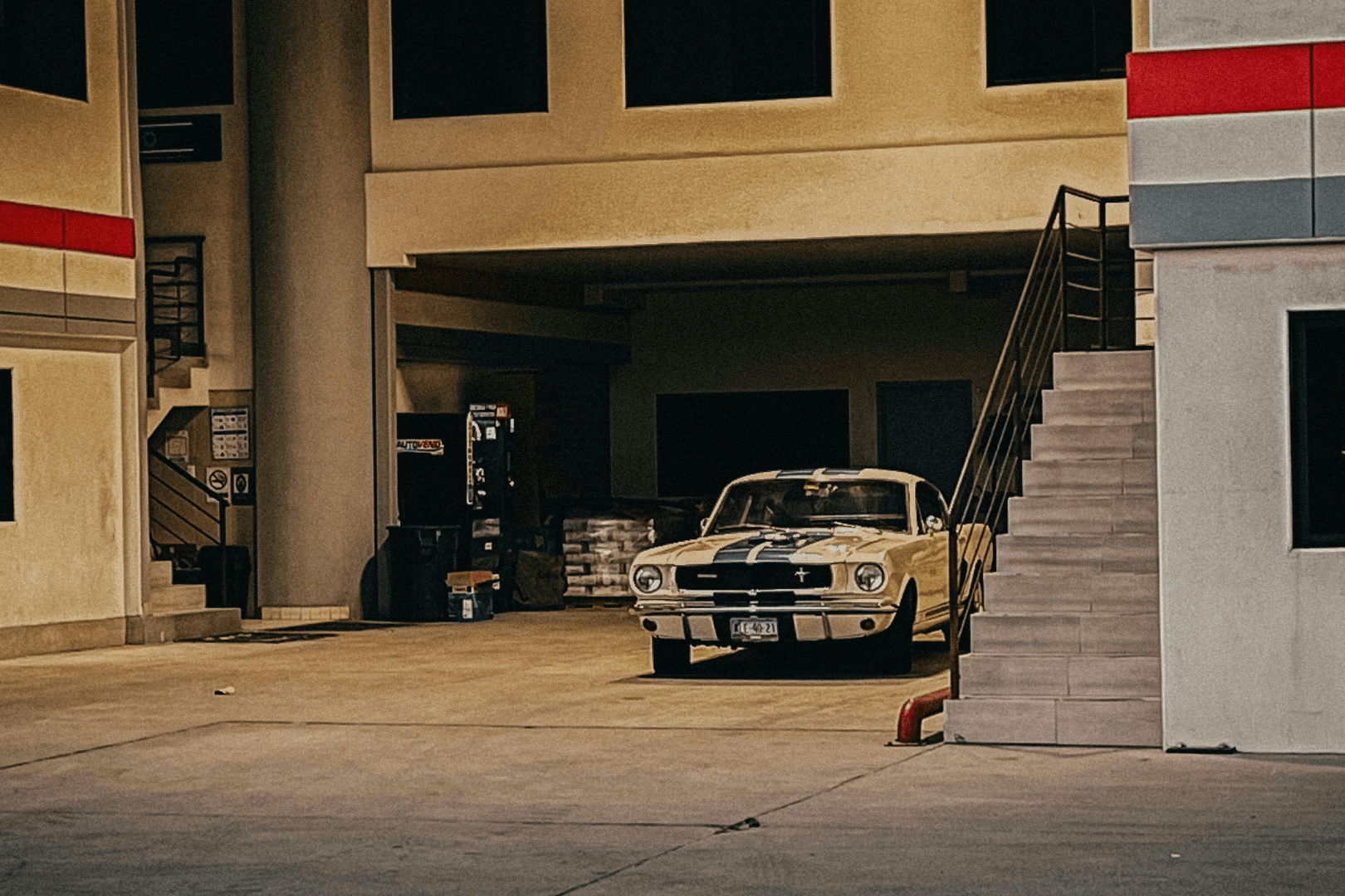 A gloved hand uses a trowel to smooth wet concrete along a brick border outdoors.