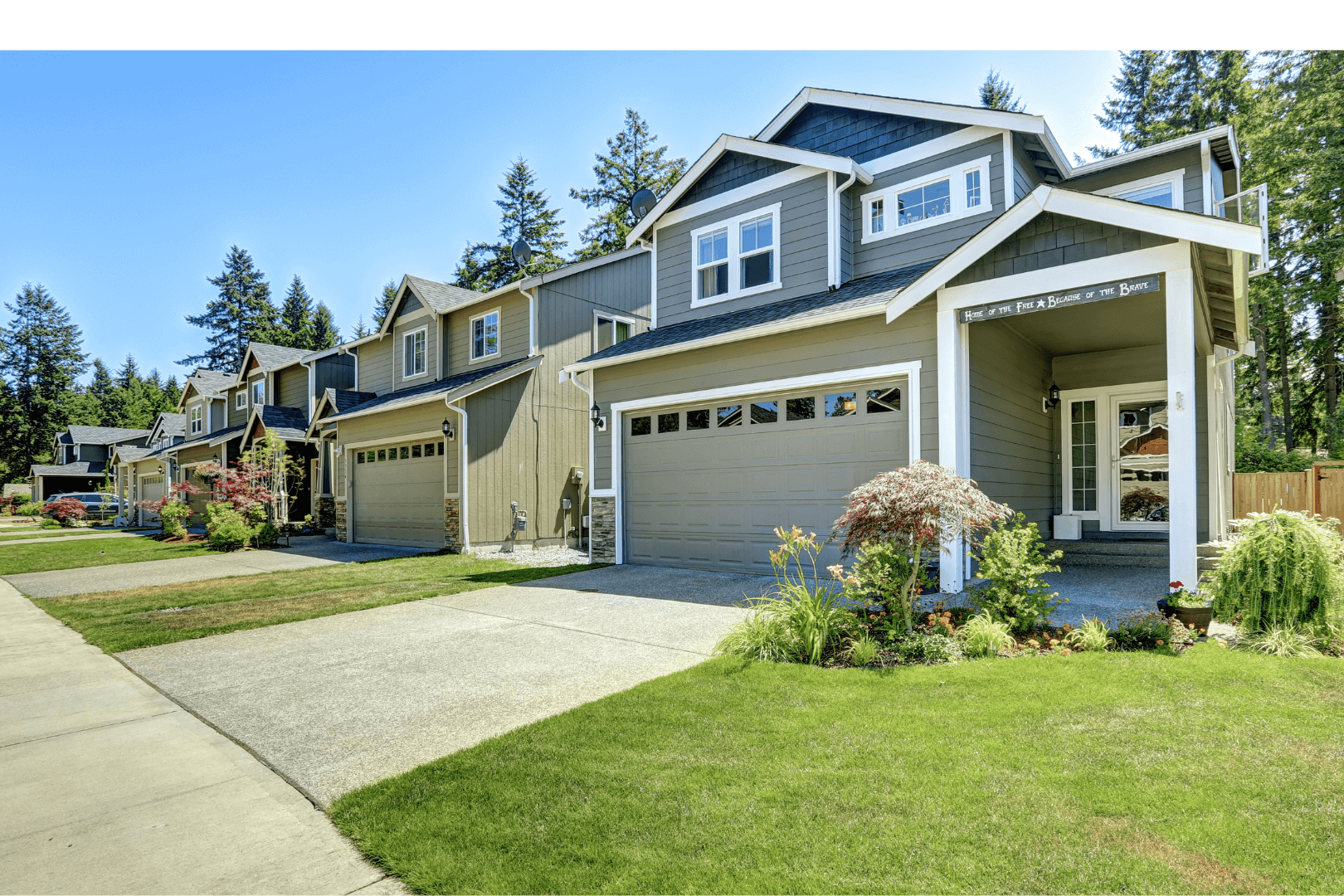Worker in orange vest rolling black asphalt strip on sandy ground. Concrete border visible.