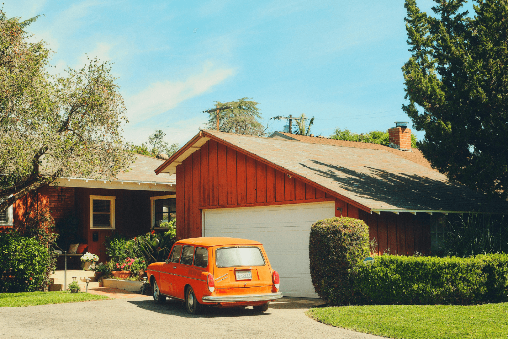 A gloved hand uses a trowel to smooth wet concrete along a brick border outdoors.