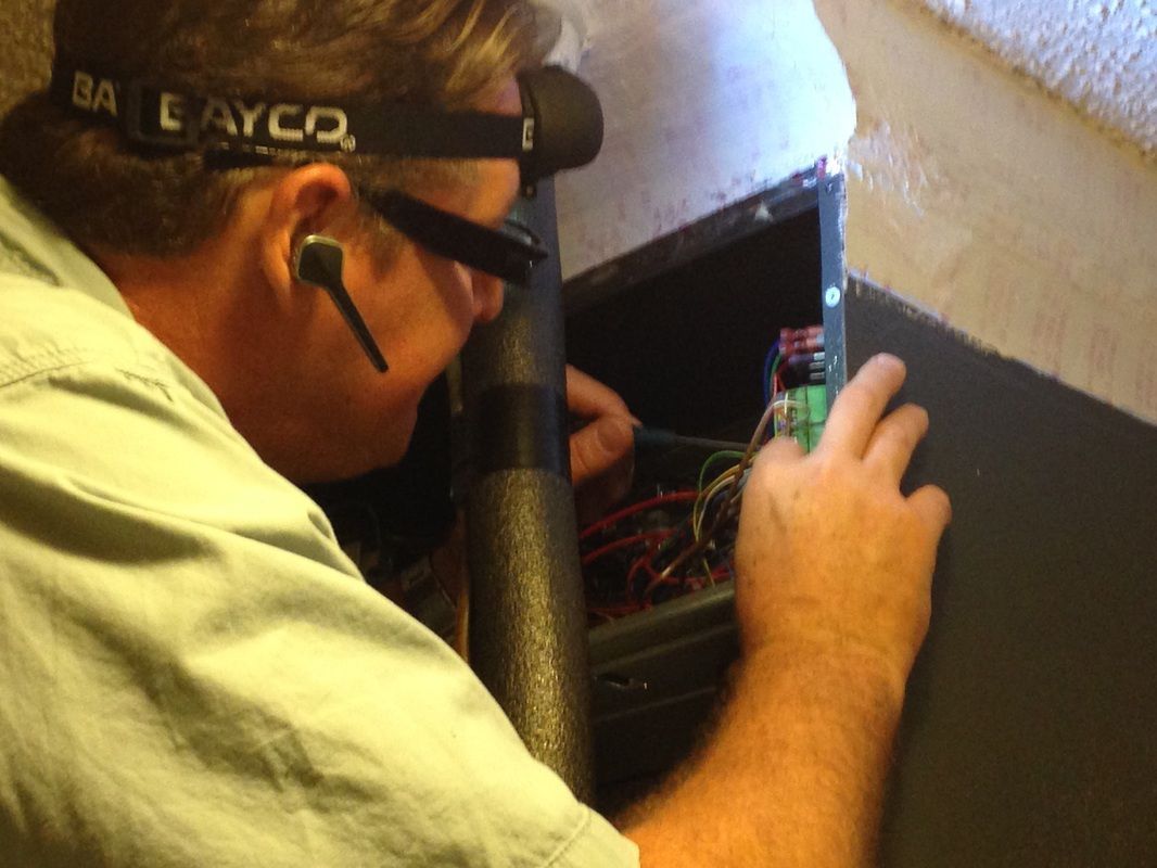 A man wearing a layco headlight is working on a computer
