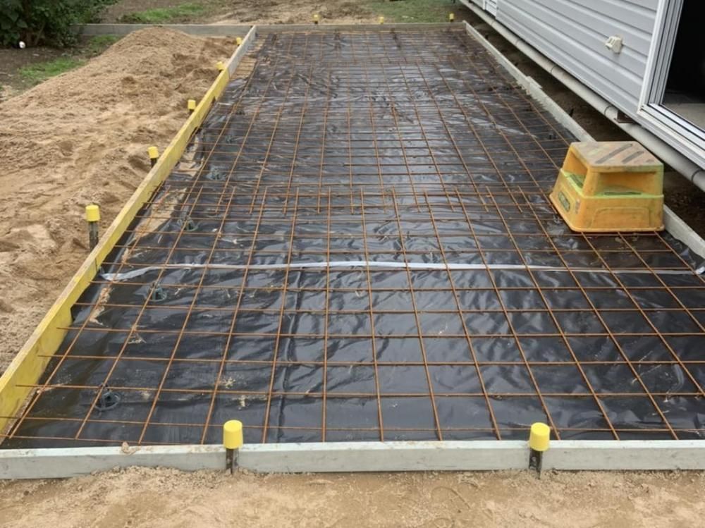A Concrete Driveway is Being Built Next to a House — Pedro's Concreting in Pittsworth, QLD