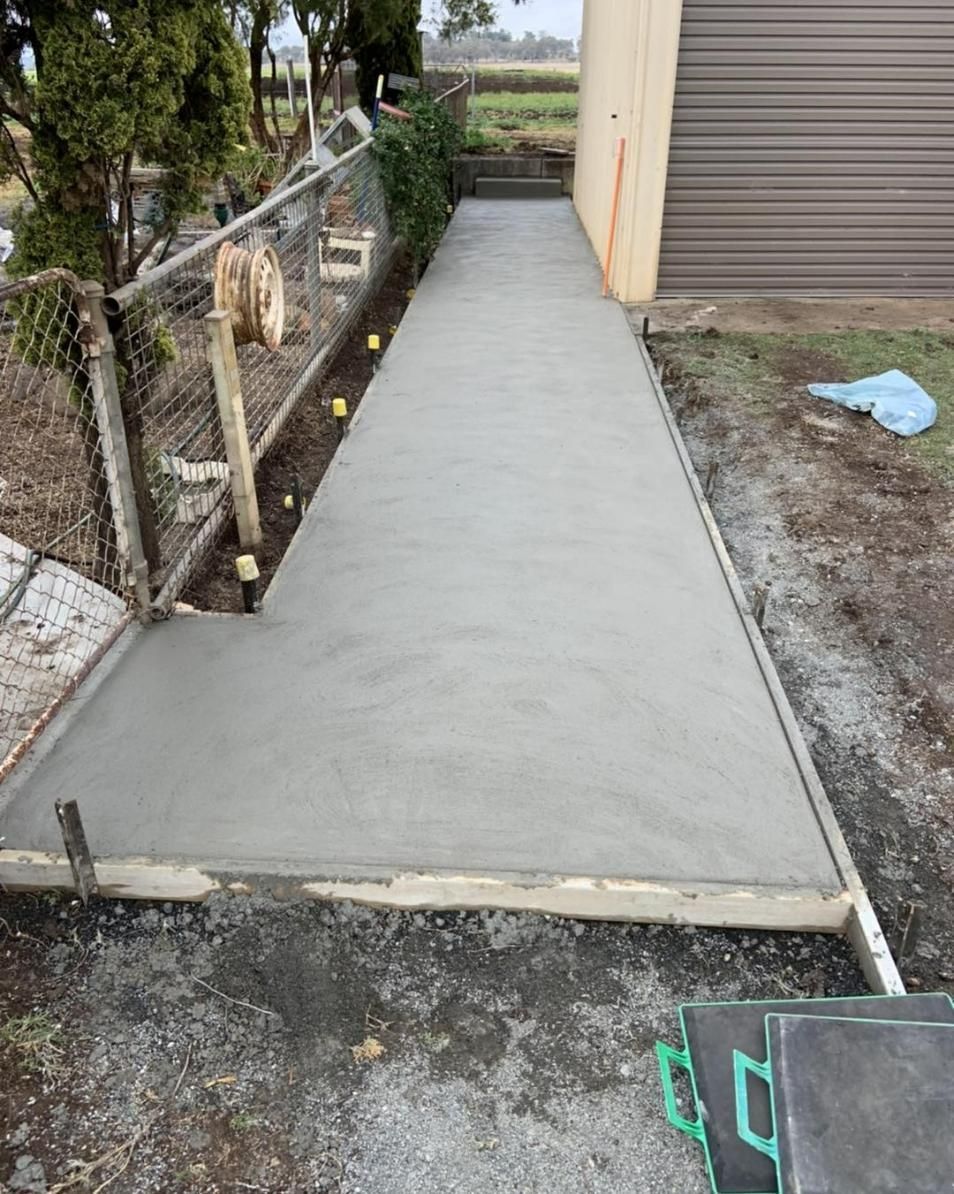 A Concrete Walkway Is Being Built Next to A Garage — Pedro's Concreting in Highfields, QLD