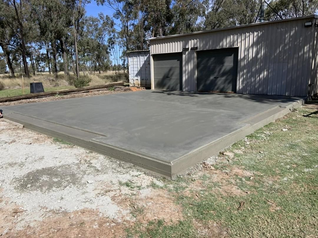 A Concrete Driveway Is Being Built in Front of A Garage — Pedro's Concreting in Pittsworth, QLD