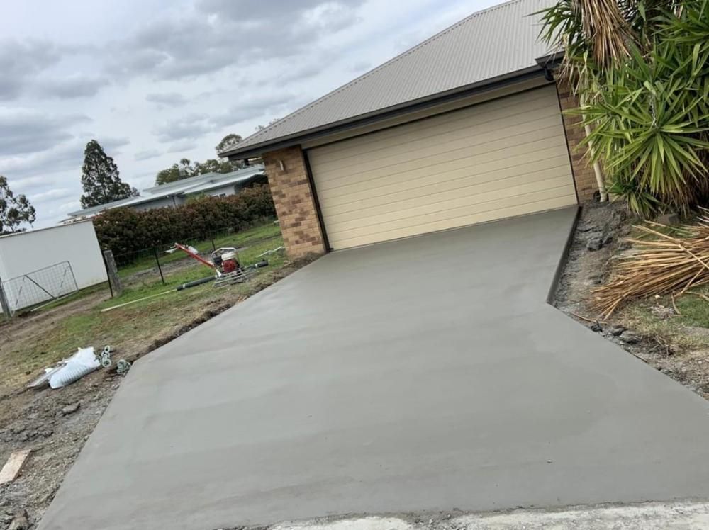 A Concrete Driveway is Being Built in Front of a Garage — Pedro's Concreting in Pittsworth, QLD