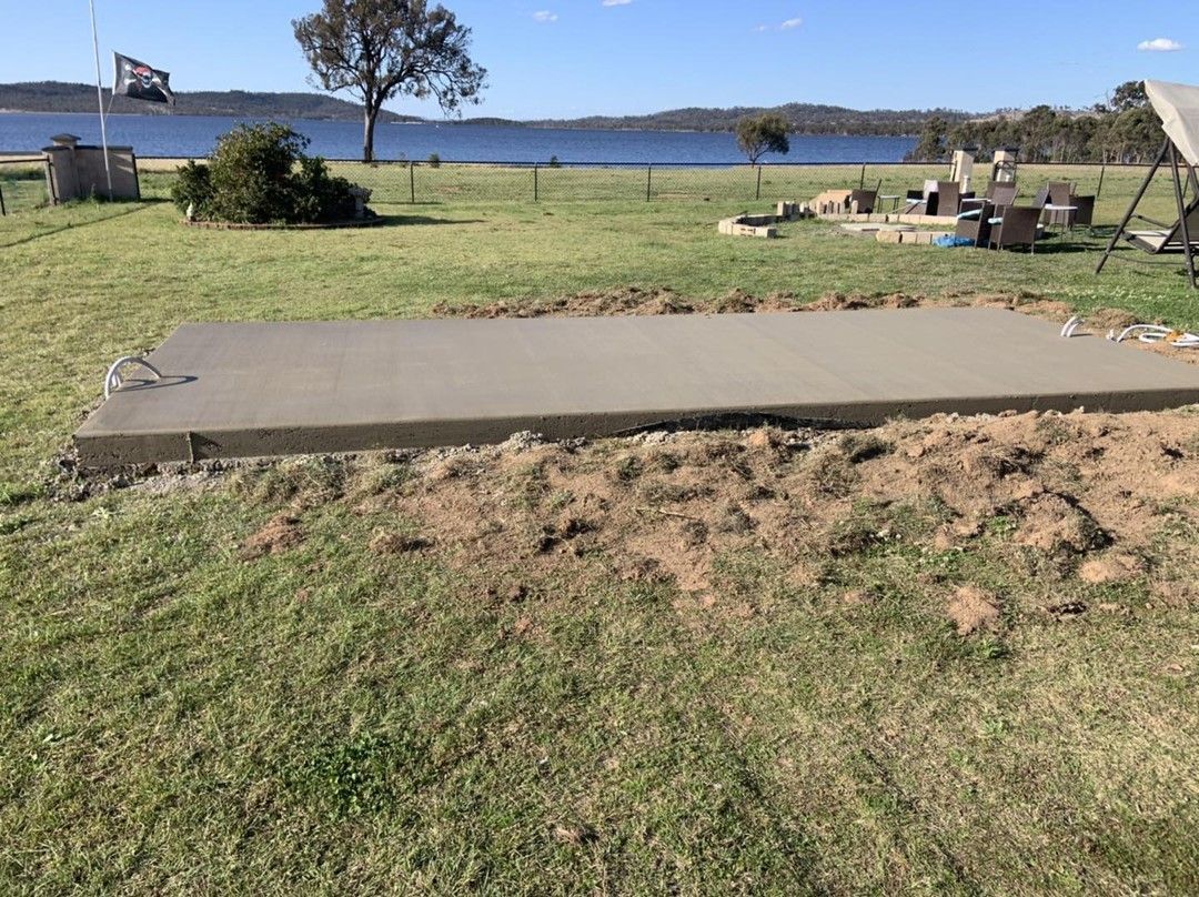 A Large Concrete Slab Is Sitting in The Middle of A Grassy Field  — Pedro's Concreting in Highfields, QLD
