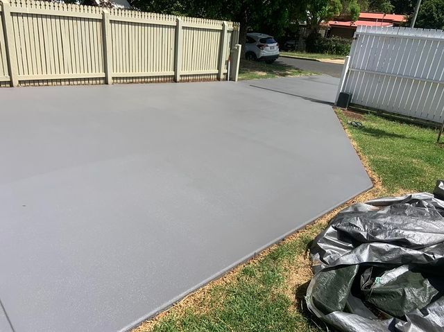 Concrete Driveway Beside a Wooden Fence — Pedro's Concreting in Pittsworth, QLD