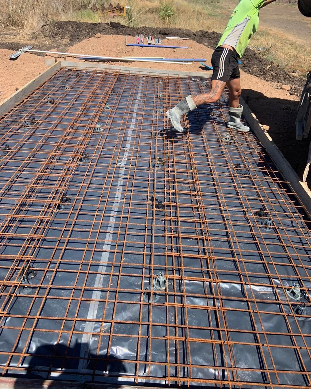 A Man in A Green Shirt Is Running on A Concrete Floor — Pedro's Concreting in Pittsworth, QLD