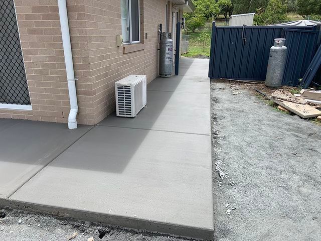 A Brick Building With a Concrete Walkway Leading to It — Pedro's Concreting in Pittsworth, QLD