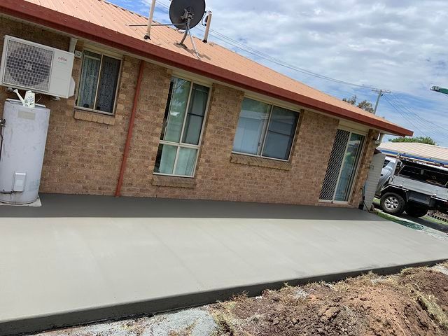 A Brick House With a Concrete Driveway — Pedro's Concreting in Pittsworth, QLD