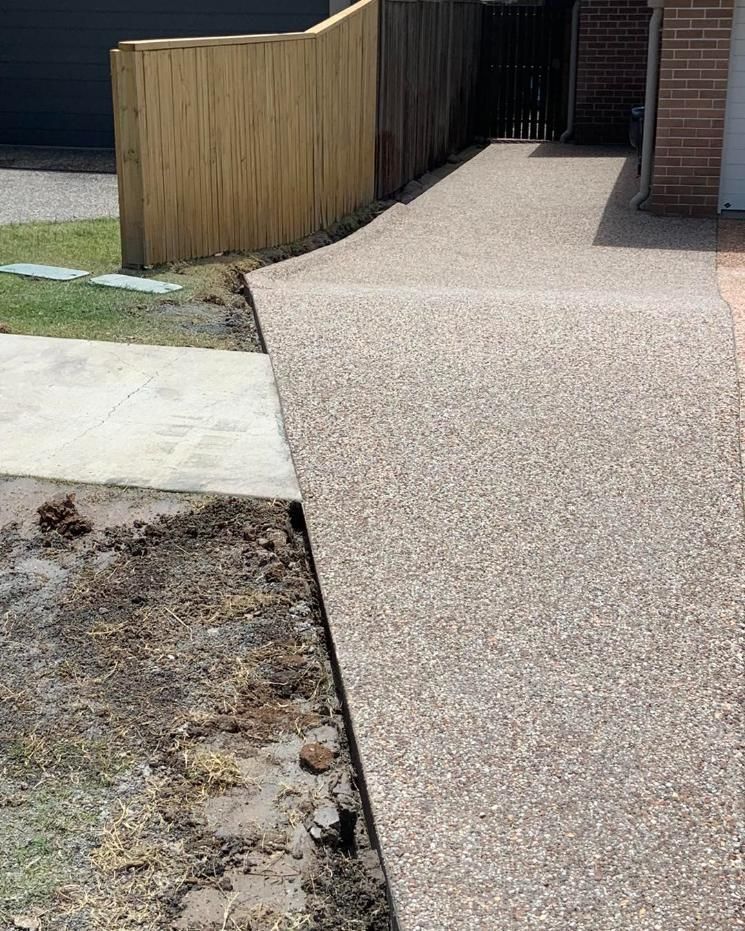 A Concrete Walkway With a Wooden Fence in the Background — Pedro's Concreting in Pittsworth, QLD