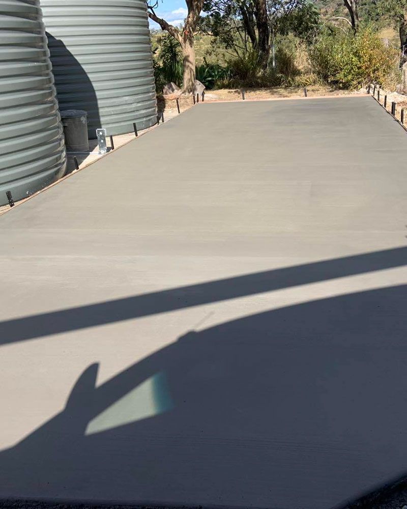 New Concrete Slab In Front Of Water Tanks — Pedro's Concreting in Pittsworth, QLD