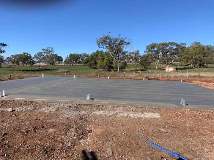 A Large Concrete Slab Is Sitting in The Middle of A Dirt Field — Pedro's Concreting in Toowoomba, QLD