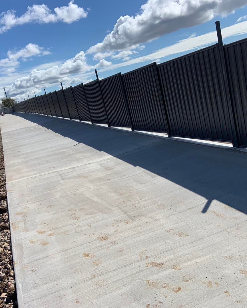 A Concrete Walkway With a Black Fence in the Background — Pedro's Concreting in Pittsworth, QLD