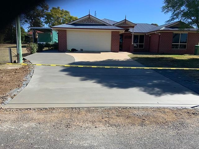 Brick House With a Concrete Driveway In Front Of It — Pedro's Concreting in Highfields, QLD